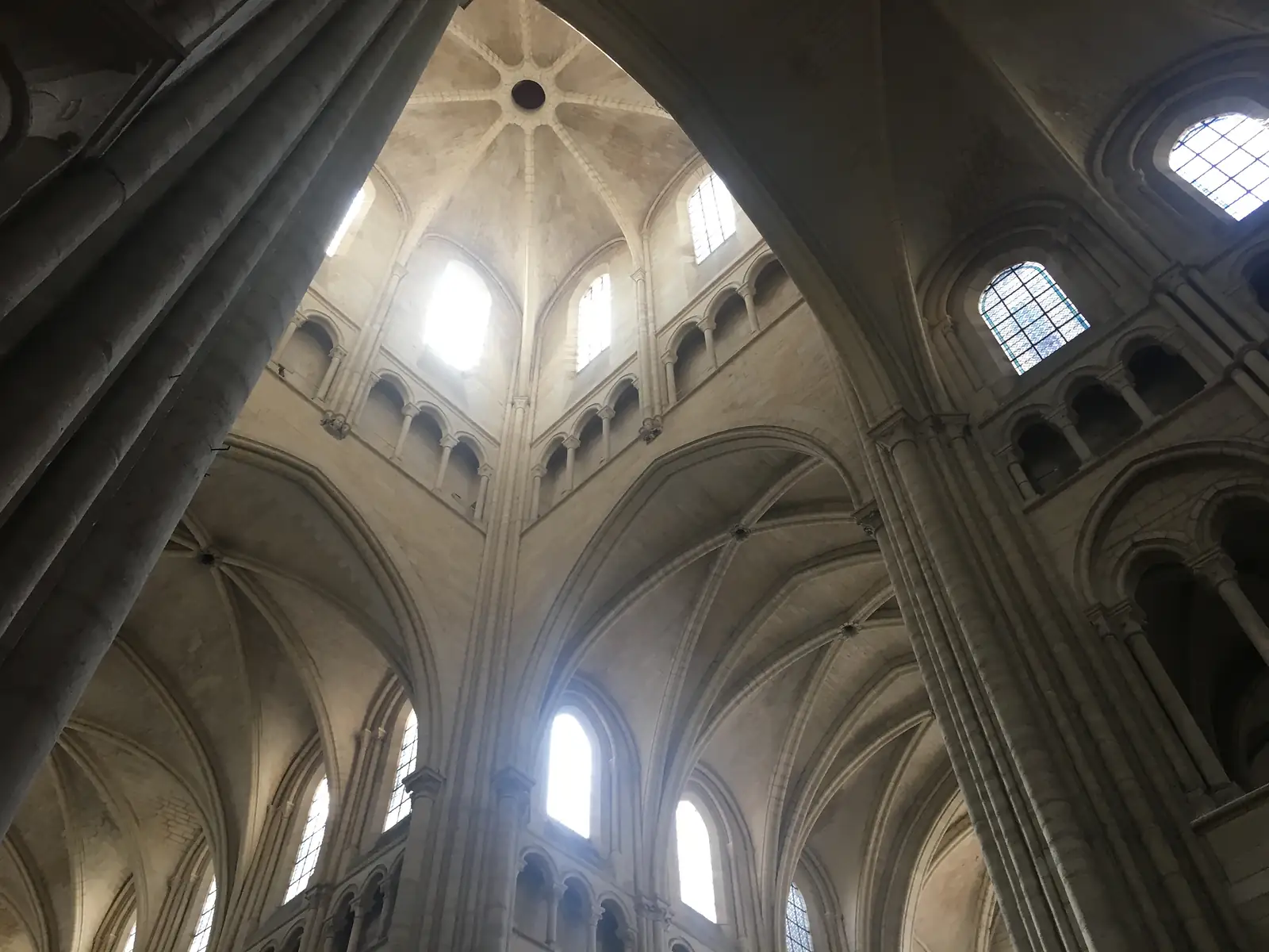 Gothic ribbed vaulting soars overhead at the crossing of the cathedral, with tall windows admitting shafts of light between the stone arches.