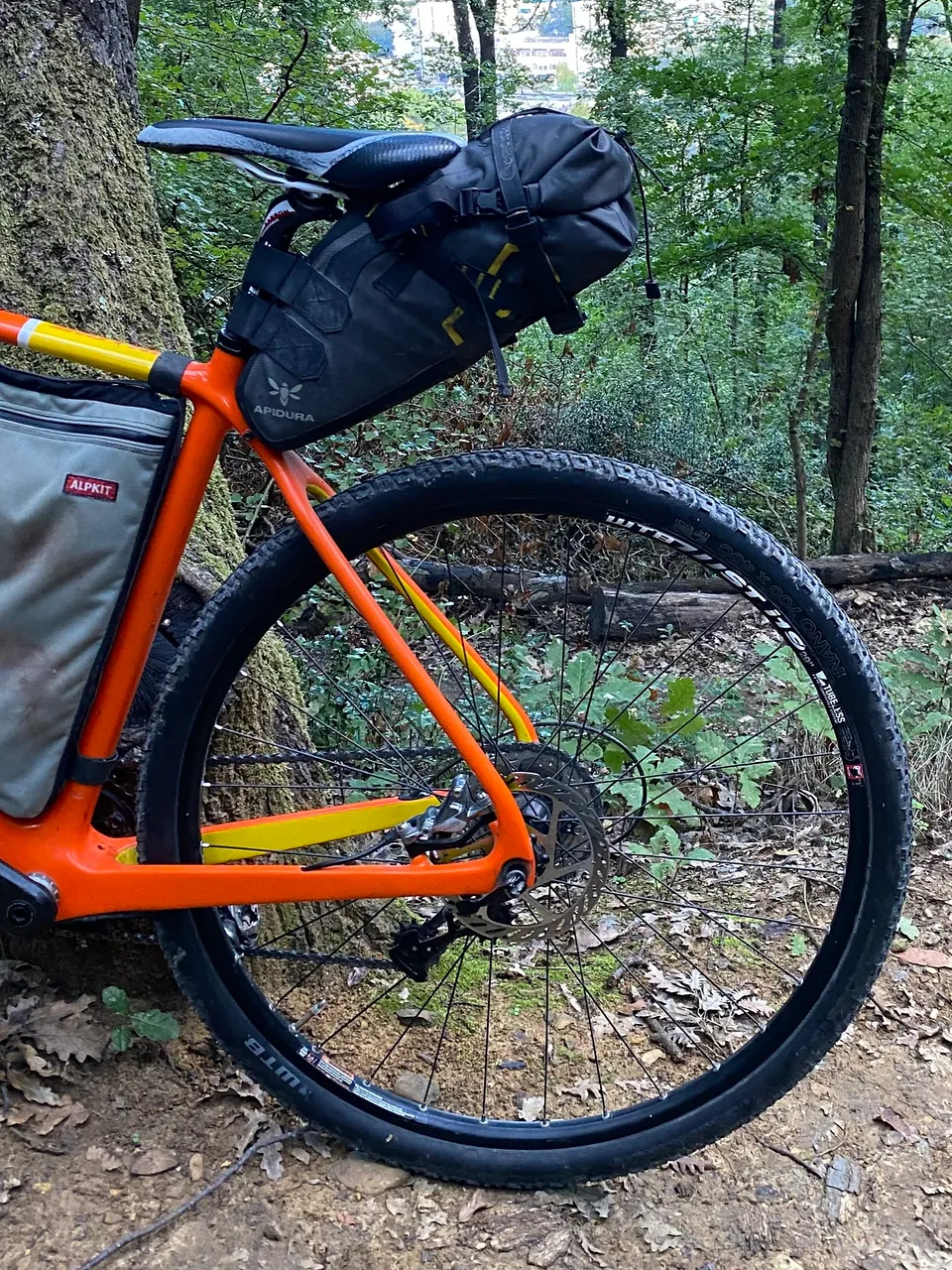 The back of an orange bike with a seat pack.