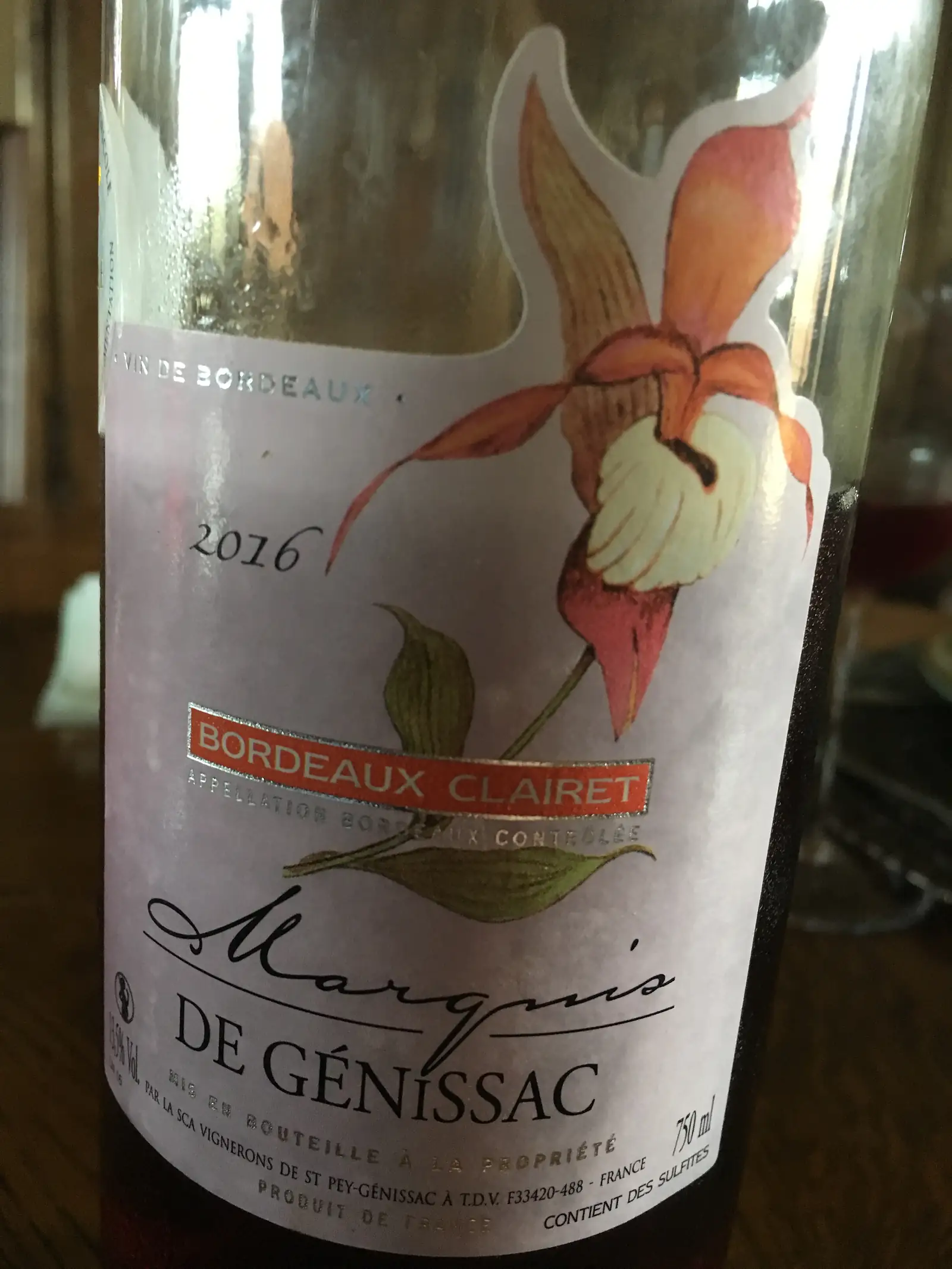 A wine bottle label for 'Marquis de Génissac', a 2016 Bordeaux Clairet, photographed at an angle indoors.