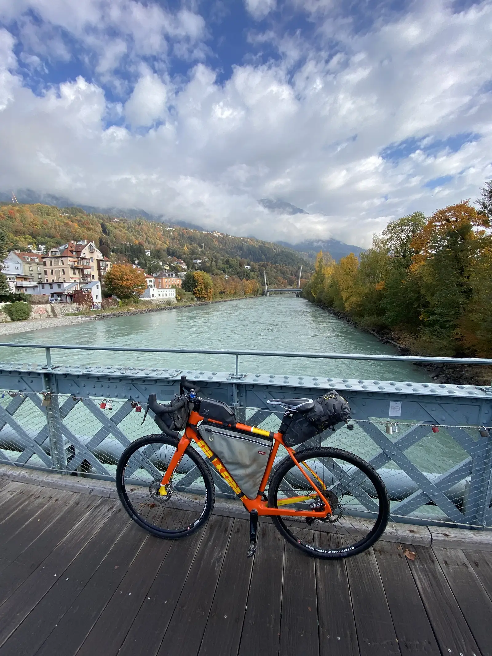 An orange bike on a bridge overlooking the river Inn in Innsbruck.