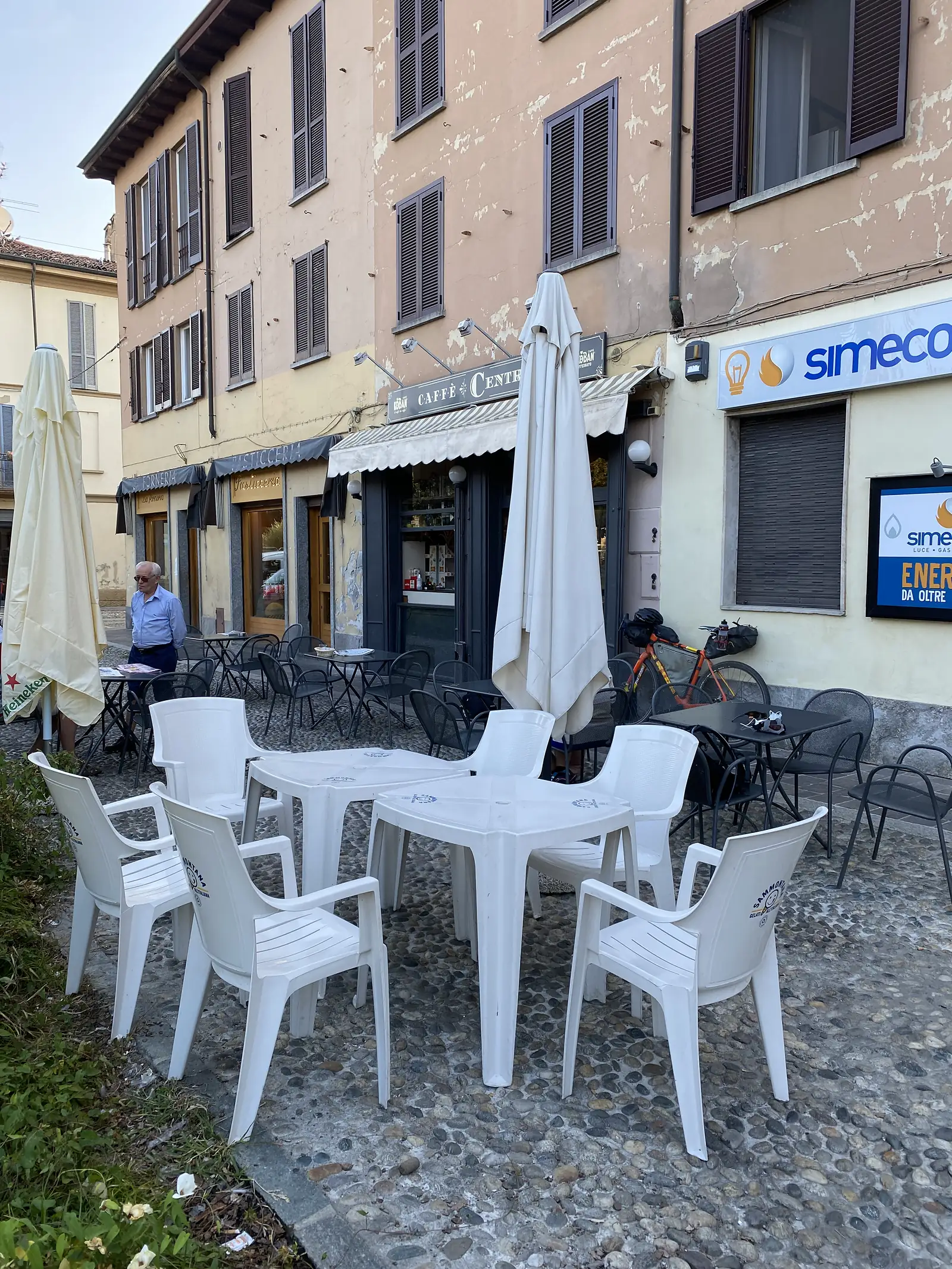 Plastic chairs outside an Italian cafe. Early morning. Nobody sitting there.