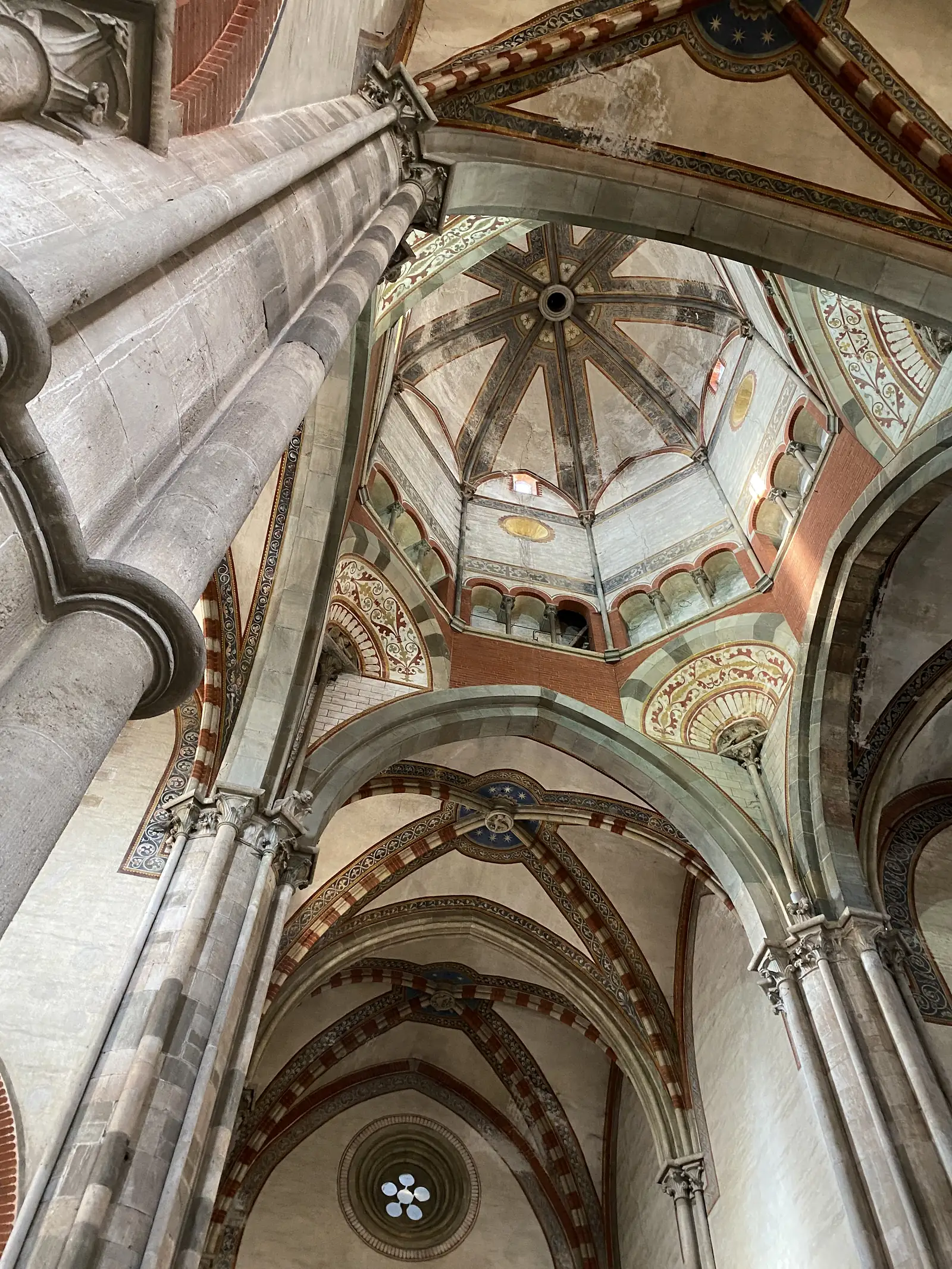 The painted and banded stone vaulting above the crossing of the basilica, its ribs converging around a small octagonal lantern.
