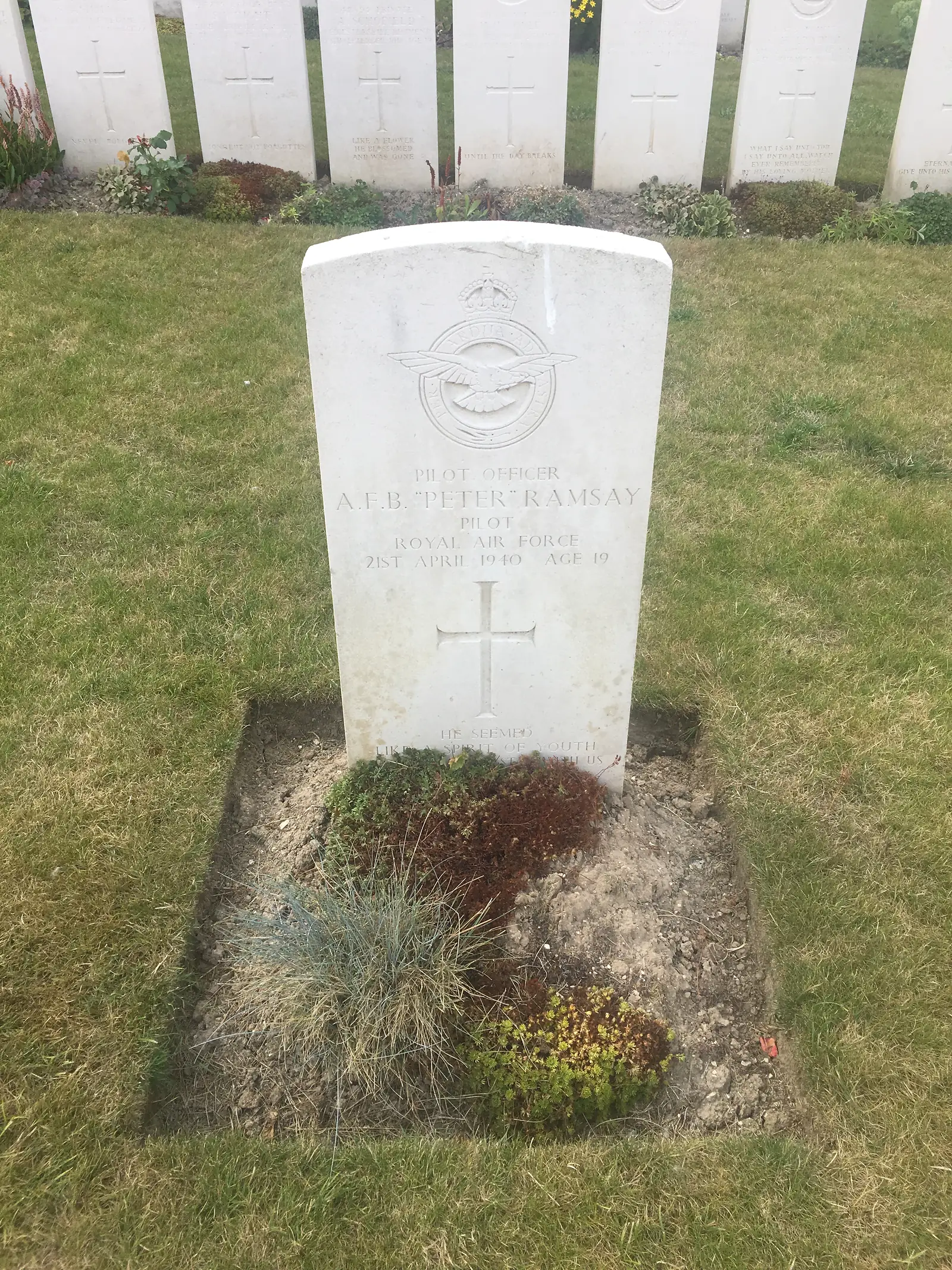 A war grave headstone inscribed Pilot Officer A.F.B. "Peter" Ramsay, Royal Air Force, 21st April 1940, Age 19, among other Commonwealth graves on the grass.