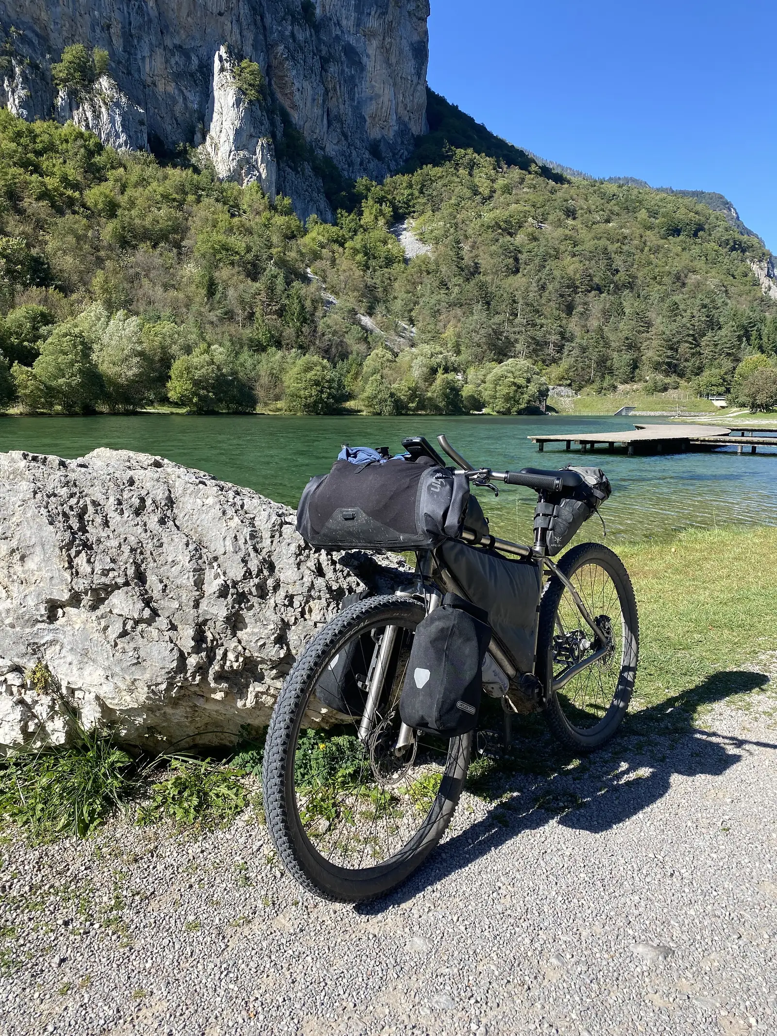 A bike leaning on a rock with a lake in the background