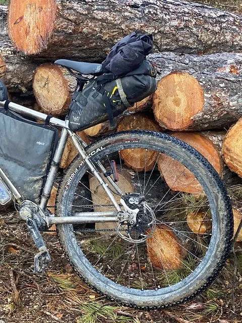 A silver bike with a seat pack.